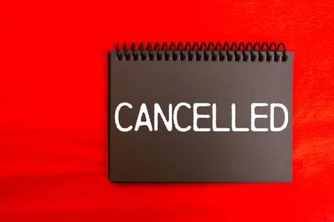 Cancelled message written on black notebook page with red background. Conce.. Stock Photos