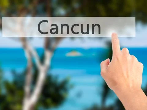 Cancun - Hand pressing a button on blurred background concept on visual scree Stock Photos