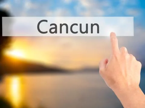 Cancun - Hand pressing a button on blurred background concept on visual scree Stock Photos