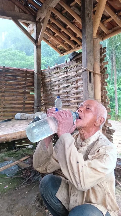 Candid Elderly Farmer Drinking Water from Large Bottle at Rural Wooden Hut Video stock 335019484