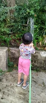 Candid Rear View of Three Year Old Boy with Water Hose Stock Photos