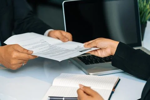 Candidate hands resume to the interviewer. uds Stock Photos