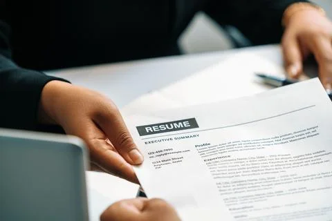 Candidate hands resume to the interviewer. uds Stock Photos