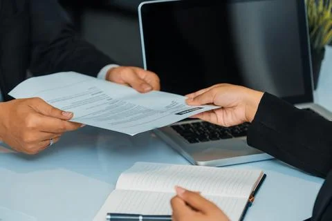 Candidate hands resume to the interviewer. uds Stock Photos