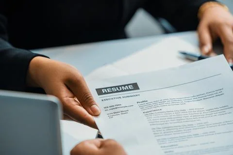 Candidate hands resume to the interviewer. uds Stock Photos
