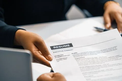 Candidate hands resume to the interviewer. uds Stock Photos