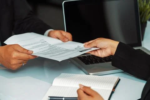 Candidate hands resume to the interviewer. uds Stock Photos