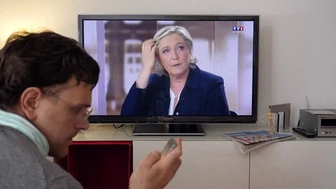Candidate supporter watching debate between Emmanuel Macron and Marine Le Pen Video stock 75288276
