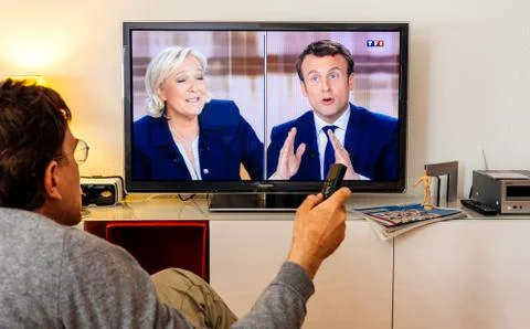 Candidate supporter watching debate between Emmanuel Macron and Marine Le Pen Foto stock