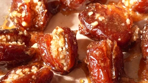 Candied dates stuffed with nuts and pepper rotating on parchment paper Stock Footage 333426398