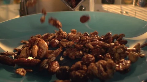 Candied mixed nuts. Poured onto plate. slomo cu Stock Footage 102139723