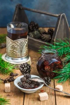 Candied young pine cones on a small plate on a wooden. Stock Photos