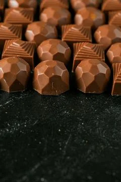 Candies are placed in a neat pattern on a dark surface Stock Photos
