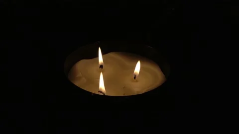 A candle with 3 lights is burning Stock Footage 232602854