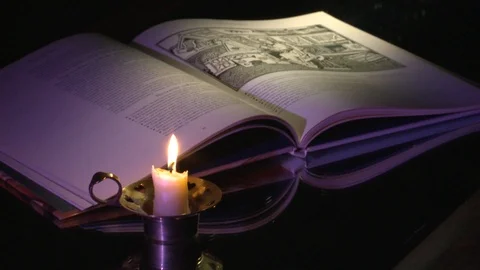 The candle and the book Stockbeeldmateriaal 97639510