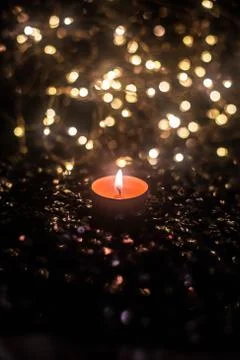 Candle on the background of the lights Stock Photos