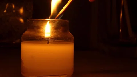 Candle being lit with a match in soft dark ambient light Vídeos de archivo 332997673