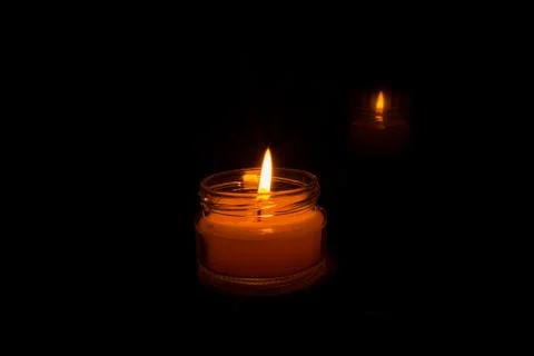 Candle on a black background. Stock Photos