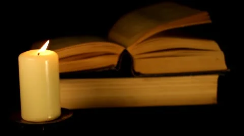 Candle blazes on background of the book Stock Footage 10701976