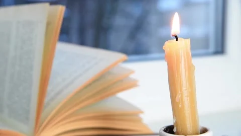 Candle burning and book on windowsill, Stock Footage 233483156