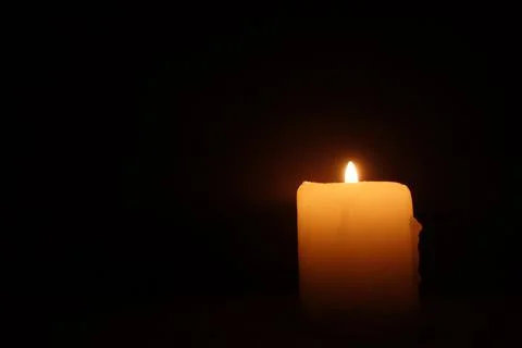 Candle burning on black background. Memory, mourning, remembrance day Stock Photos