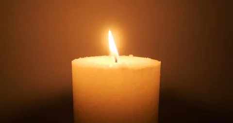 Candle burning bright in the darkness, flame emitting orange glow Stock Footage 129973330