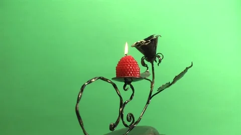 Candle burning on a candlestick on a green background Stock Footage 1079395