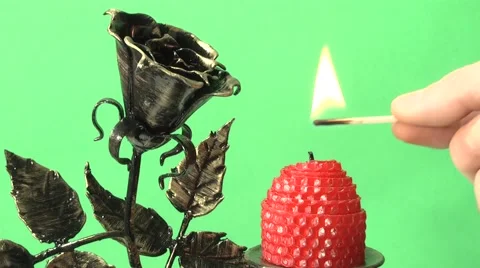 Candle burning on a candlestick on a green background Stock Footage 1079404