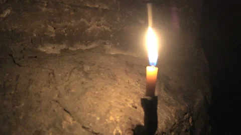Candle burning in a cave Stock Footage 98493833