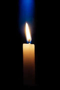 Candle is burning on a dark background Stock Photos