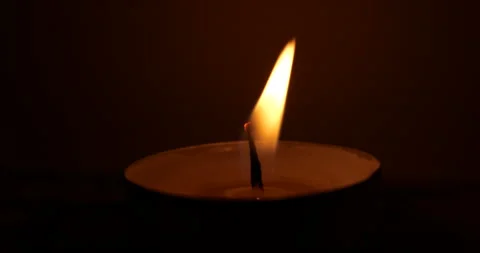 A candle burning in the dark. wind blowing on a candle. wind blowing on a flame Stock Footage 310335078