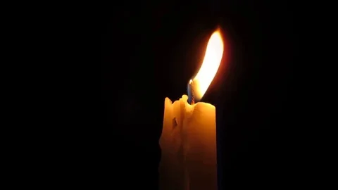 A candle burning in the darkness. The flame swayed in the wind. Video. 스톡 동영상 104629588