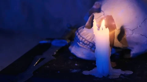 Candle burning in front of ritual human skull. Deadly ritual. Witchcraft concept Stock Footage 139327518