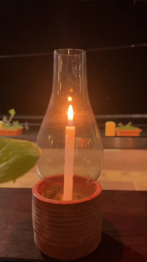 The candle is burning, it is in a candlestick, there is low lighting. Stock Footage 322626059