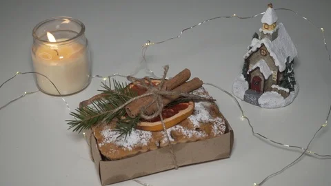 Candle burning next to a Christmas cake Stock Footage 100889132