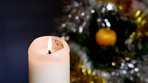 A candle burns against the background of a decorated Christmas tree. Meditation. Stock Footage 166457076