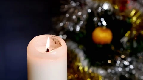 A candle burns against the background of a decorated Christmas tree. Stock Footage 167326708