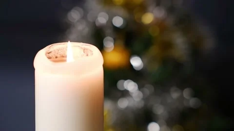 A candle burns against the background of a decorated Christmas tree. Stock Footage 167366117