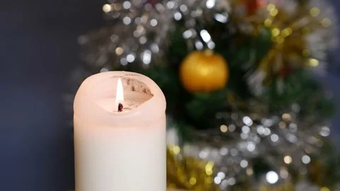 A candle burns against the background of a decorated Christmas tree. Stock Footage 167656774