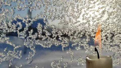 A candle burns against the background of iced glass 5 Stock Footage 327036686