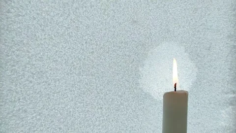 A candle burns against the background of iced glass 3 Stock Footage 327036775