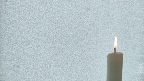 A candle burns against the background of iced glass Stock Footage 327036876