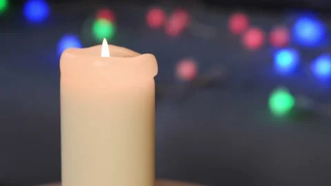 The candle burns against the background of multi-colored lanterns. Stock Footage 166163465