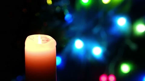 A candle burns on a blurred dark background with burning lanterns. Stock Footage 168739963