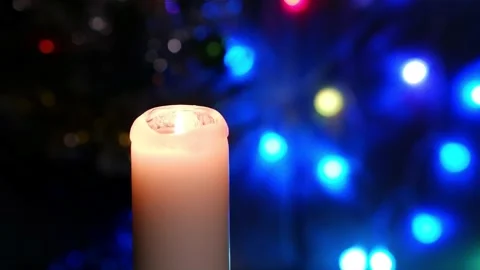 A candle burns on a blurred dark background with burning lanterns. Stock Footage 168895835