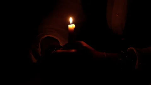 The candle burns in the dark. Close-up, variable focus. Candle fire in male Stock Footage 241791749