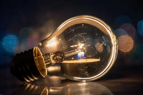 A candle burns instead of a light bulb, saving energy Stock Photos