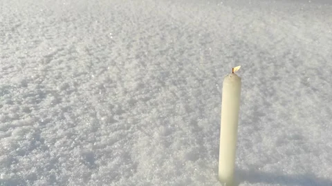 A candle burns in the snow Stock Footage 327546826