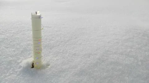 A candle burns in the snow Stock Footage 328425752