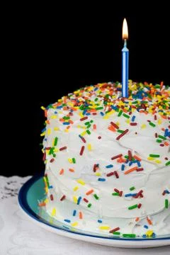 Candle on cake with sprinkles Stock Photos